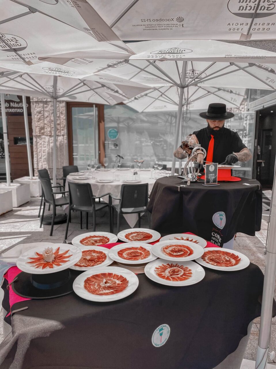 Julio García realizando corte artístico de jamón en evento elegante bajo carpa en Galicia, ideal para bodas, aniversarios y celebraciones en A Coruña, Lugo, Ourense y Pontevedra.