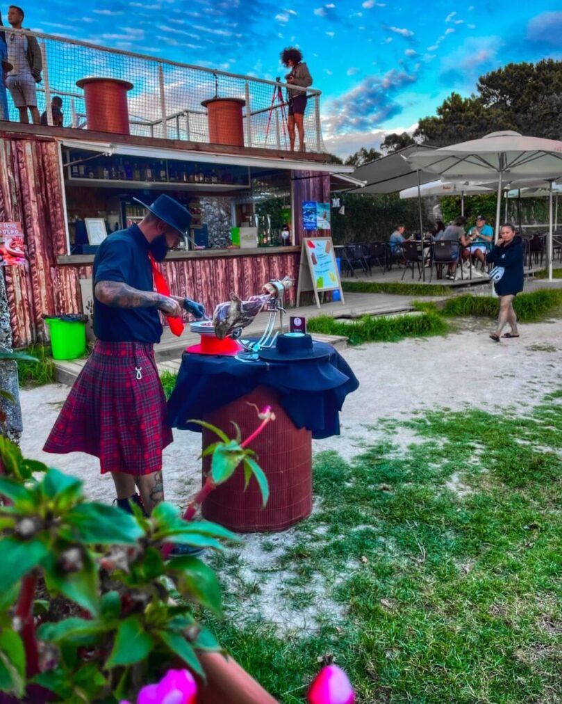 Corte artístico de jamón en A Illa de Arousa por Galician Ham Carver durante un evento al aire libre en la playa