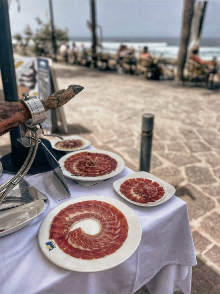 Platos de jamón ibérico cortado por Julio García de Galician Ham Carver frente al mar en Tenerife para bodas y celebraciones exclusivas.