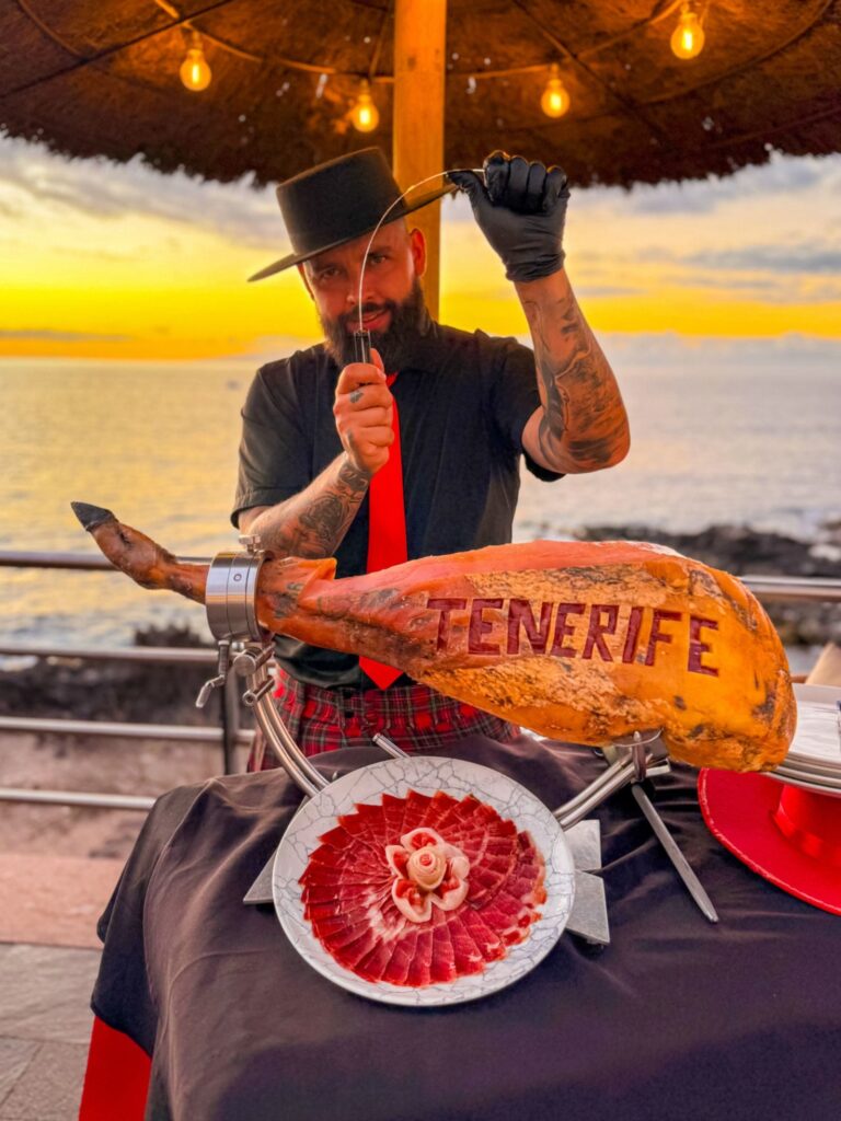 Julio García, cortador profesional de Galician Ham Carver, cortando jamón ibérico con vistas al mar, durante un evento exclusivo.