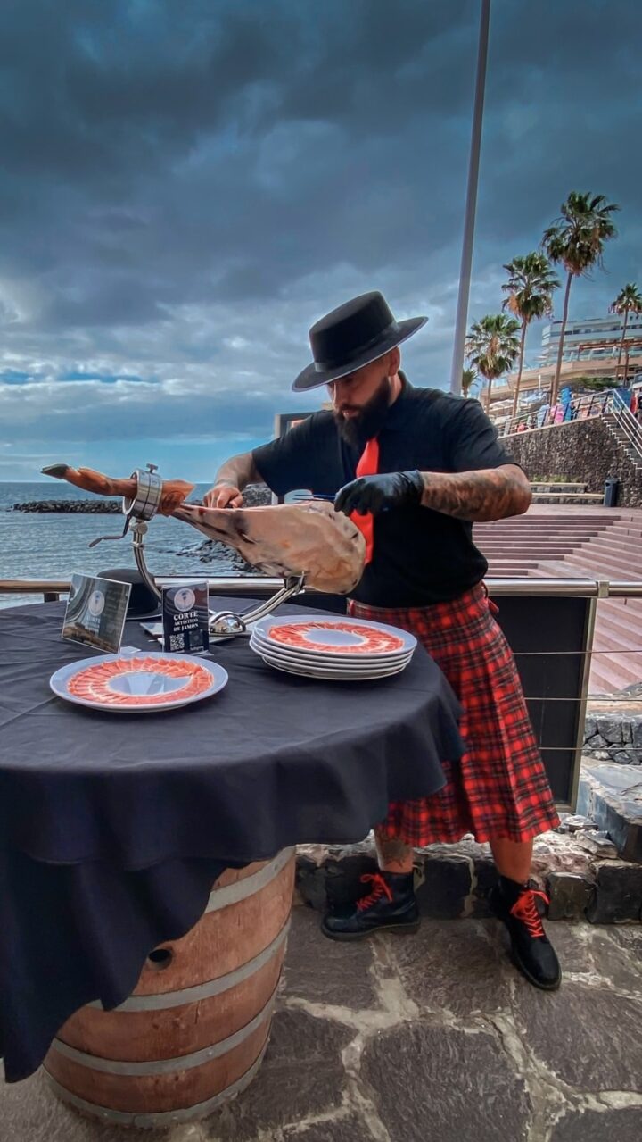 Julio García, maestro cortador de Galician Ham Carver, realizando un corte de jamón ibérico frente al mar en Canarias, ideal para bodas, comuniones y eventos exclusivos en Tenerife, Gran Canaria, Lanzarote, Fuerteventura, La Palma, La Gomera, El Hierro y La Graciosa.