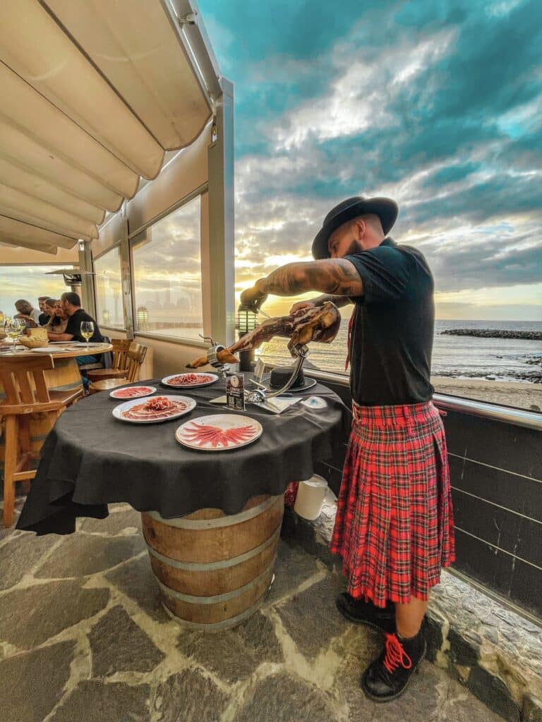 Julio García, cortador de jamón en bodas y eventos en Gran Canaria, sirviendo jamón ibérico junto al mar.