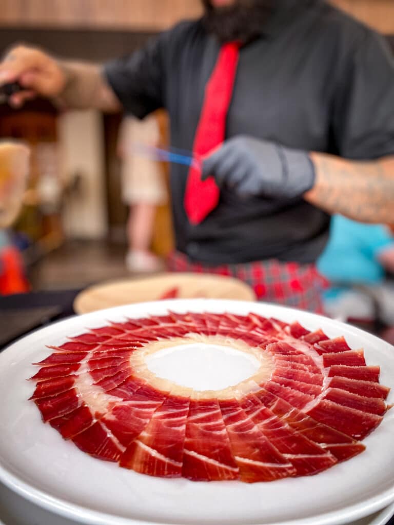 Plato de jamón ibérico cortado de forma artística en evento privado en A Coruña, servido por cortador profesional para bodas, celebraciones y eventos gastronómicos.