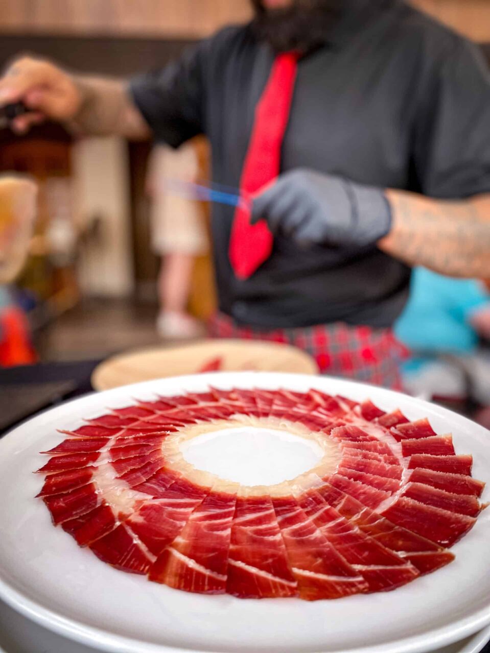 Plato de jamón ibérico cortado de forma artística en evento privado en A Coruña, servido por cortador profesional para bodas, celebraciones y eventos gastronómicos.