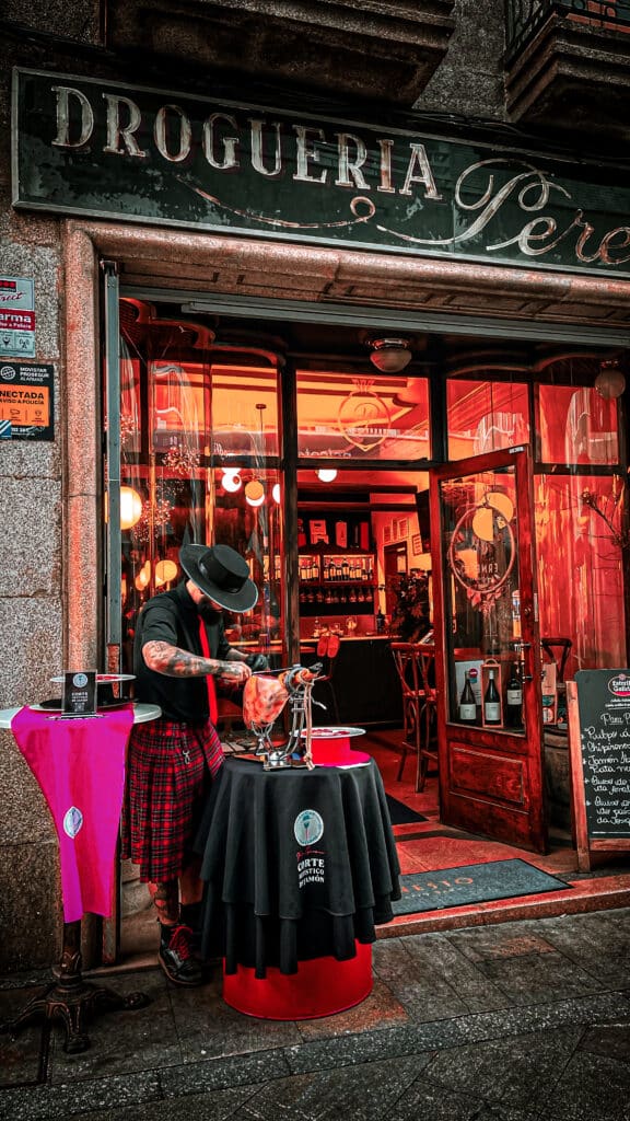 Cortador de jamón ibérico en O Carballiño realizando corte a cuchillo en directo en Ernesto Patio Bar, durante evento gastronómico local.