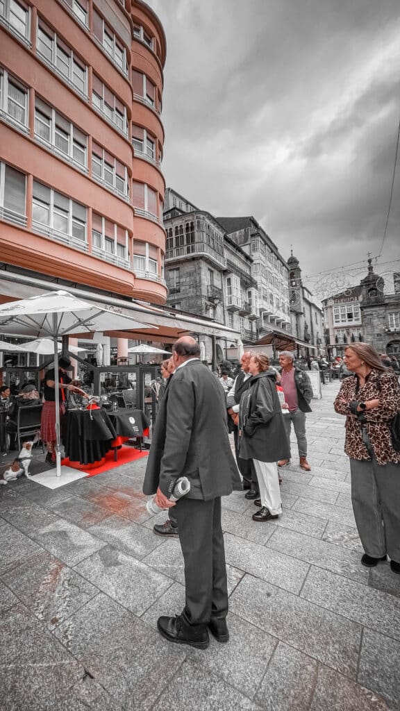 Julio García, cortador artístico de jamón durante las Fiestas de San Froilán en Lugo, con público disfrutando del espectáculo en la calle.