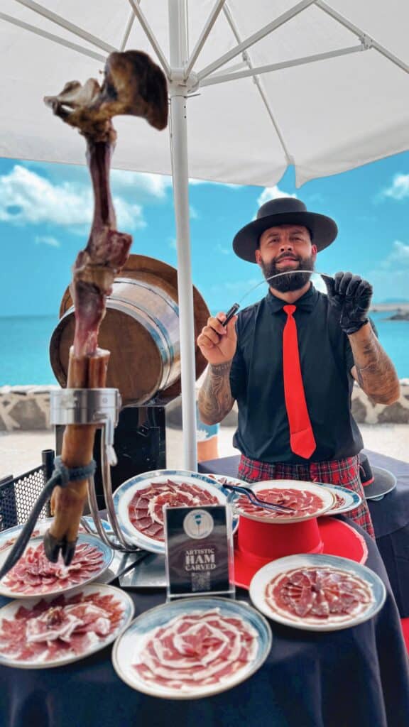 Exhibición de emplatados de jamón ibérico estilo artístico en evento frente al mar en Canarias, a cargo de Julio García, maestro cortador de Galician Ham Carver, especializado en bodas y celebraciones en Tenerife, Gran Canaria y otras islas del archipiélago.