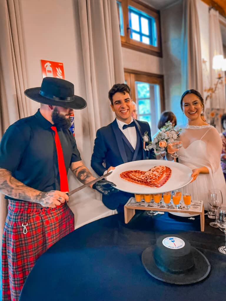 Julio García de Galician Ham Carver cortando jamón en forma de corazón junto a una pareja de recién casados durante una boda