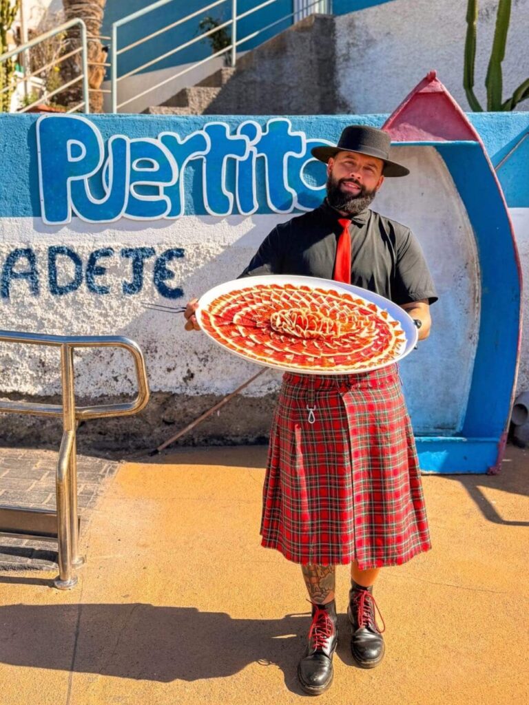 Plato artístico de jamón ibérico en El Puertito de Adeje – Galician Ham Carver Julio García, Galician Ham Carver, con un plato grande de jamón ibérico cortado artísticamente en El Puertito de Adeje, Tenerife